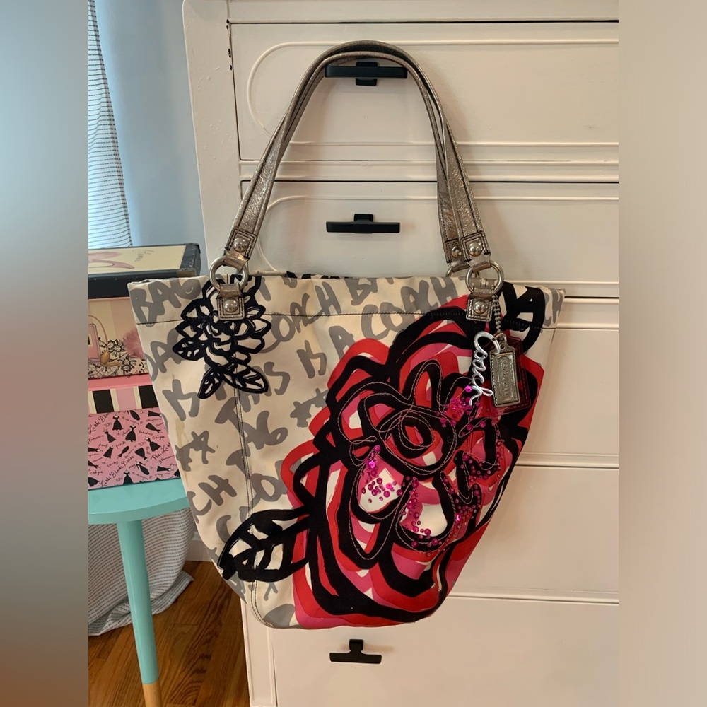 COACH Poppy bag with black and pink floral and silver hardware.